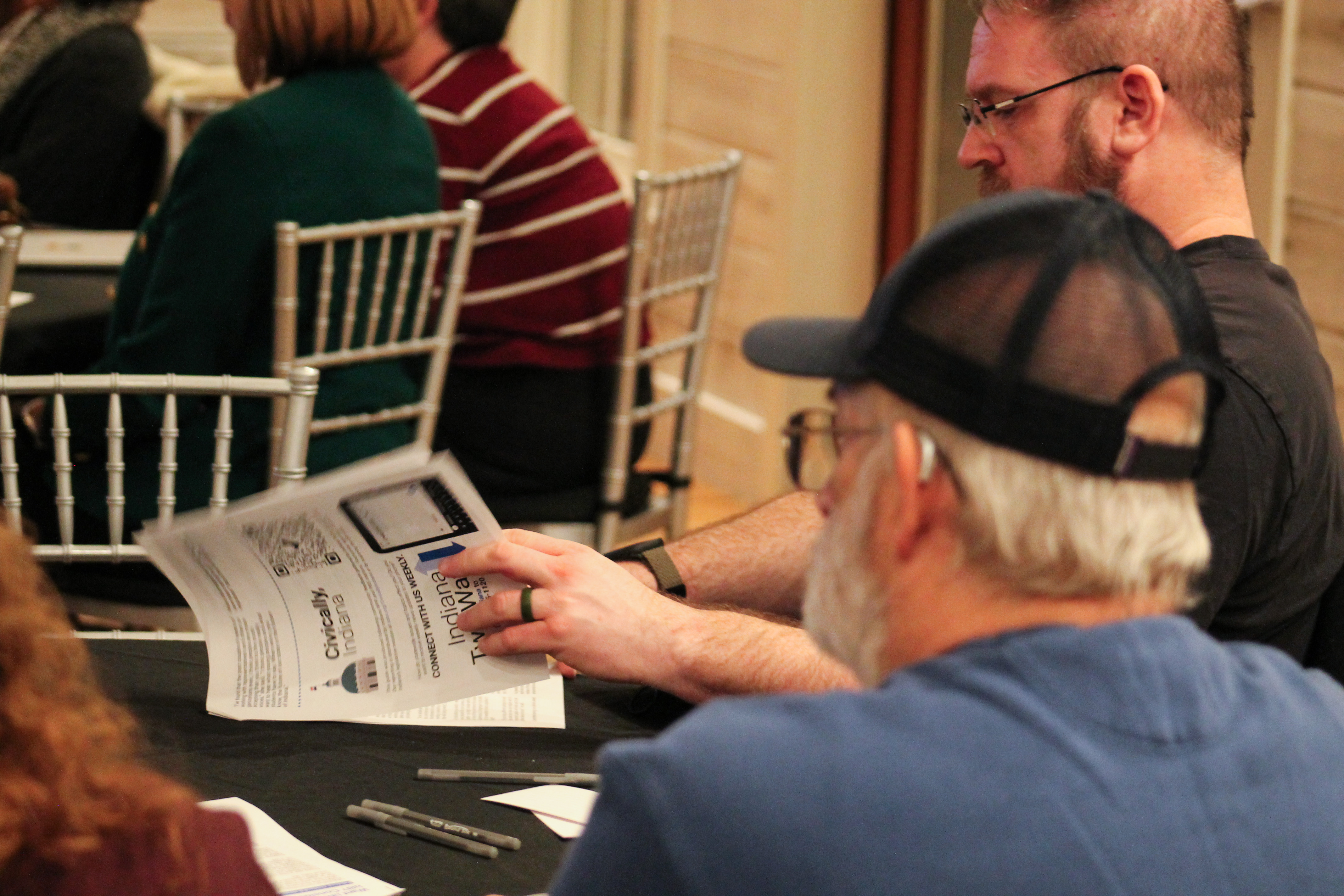 Attendees at a Civically, Indiana workshop flip through a resource packet.